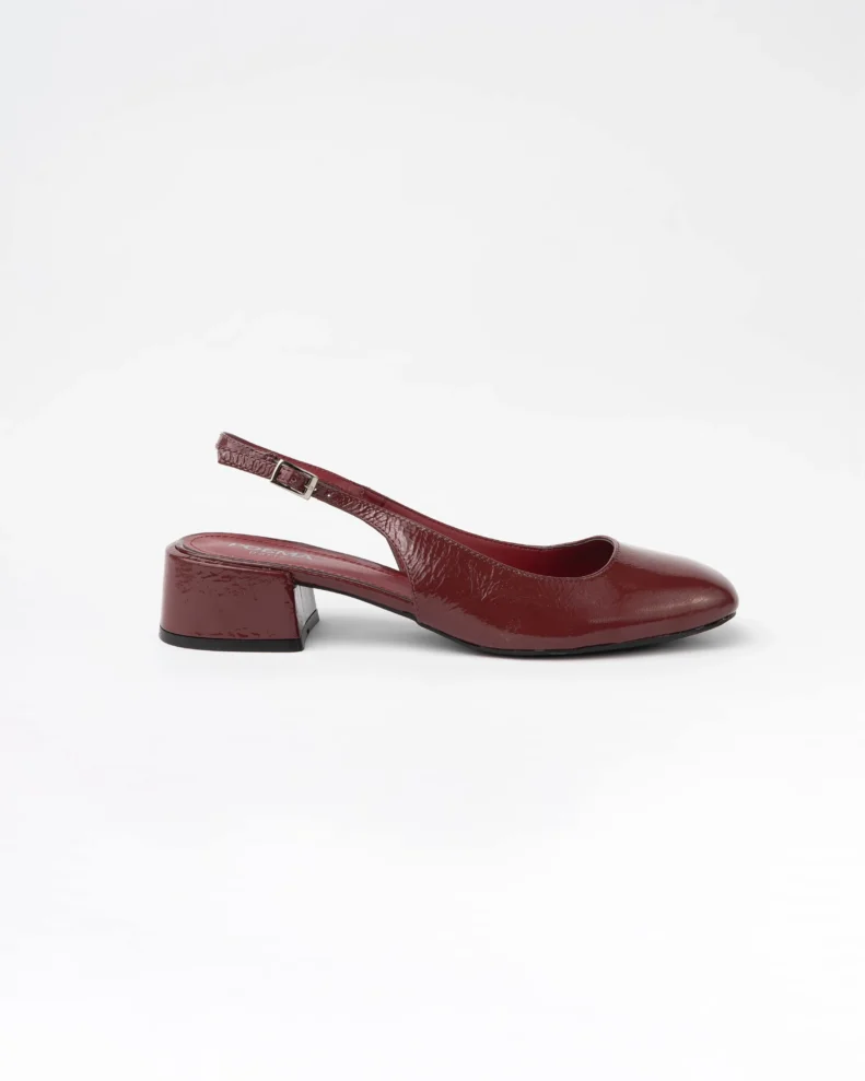 Escarpin slingback pour femme en cuir verni bordeaux lisse certifié LWG, avec bout rond légèrement structuré, talon bloc bas et stable d’environ 3,5 cm, et bride arrière réglable avec boucle métallique. Un modèle élégant, confortable et durable, parfait pour un usage quotidien ou professionnel.