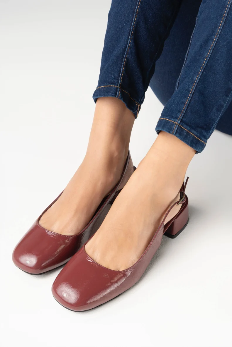 Escarpin slingback pour femme en cuir verni bordeaux lisse certifié LWG, avec bout rond légèrement structuré, talon bloc bas et stable d’environ 3,5 cm, et bride arrière réglable avec boucle métallique. Un modèle élégant, confortable et durable, parfait pour un usage quotidien ou professionnel.
