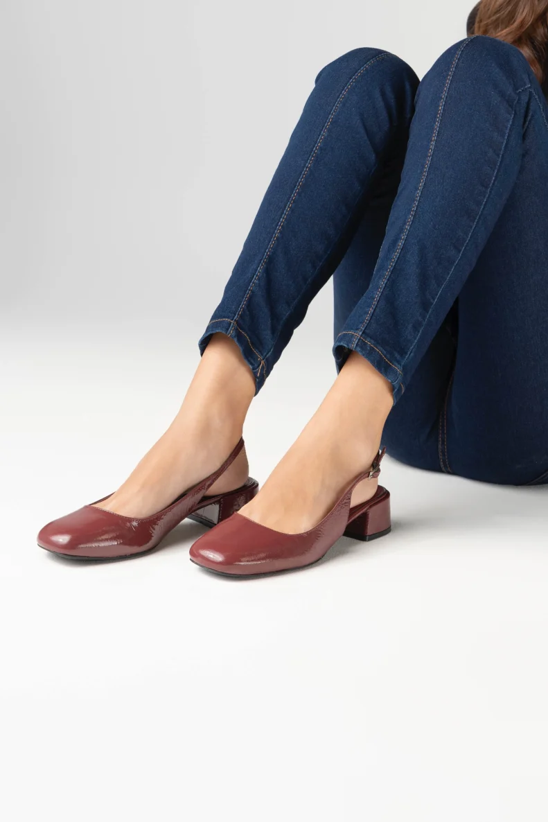 Escarpin slingback pour femme en cuir verni bordeaux lisse certifié LWG, avec bout rond légèrement structuré, talon bloc bas et stable d’environ 3,5 cm, et bride arrière réglable avec boucle métallique. Un modèle élégant, confortable et durable, parfait pour un usage quotidien ou professionnel.